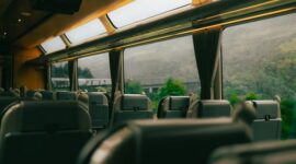 Sebuah kereta wisata melintas di jalur perbukitan yang menyajikan pemandangan alam hijau, menjadi salah satu alternatif akses pilihan favorit pelancong menuju destinasi liburan.