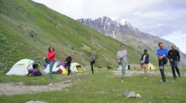 Pemandangan padang rumput pegunungan Tian Shan di Kyrgyzstan dengan tenda tradisional yurt di bawah naungan puncak bersalju.