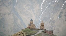 Gereja Gergeti Trinity berdiri anggun di latar belakang hamparan Pegunungan Kaukasus dan Puncak Gunung Kazbek di Georgia.