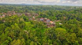 Lanskap pedesaan hijau di kaki pegunungan Nusantara yang menyajikan pemandangan asri serta udara segar bagi para pelancong yang mencari ketenangan dari hiruk-pikuk perkotaan.