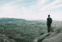 Seorang pendaki berdiri menatap hamparan lembah dan puncak es abadi di Patagonia Chile, menggambarkan tantangan serta keindahan alam liar yang menjadi tujuan favorit para penjelajah dunia.