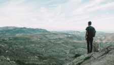 Seorang pendaki berdiri menatap hamparan lembah dan puncak es abadi di Patagonia Chile, menggambarkan tantangan serta keindahan alam liar yang menjadi tujuan favorit para penjelajah dunia.
