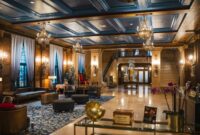 Interior lobi hotel bersejarah berarsitektur klasik yang menampilkan perpaduan lampu kristal dan furnitur kuno terawat rapi.