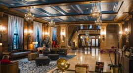 Interior lobi hotel bersejarah berarsitektur klasik yang menampilkan perpaduan lampu kristal dan furnitur kuno terawat rapi.