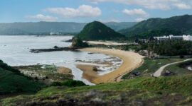 Pemandangan bukit sabana dan laut biru jernih di salah satu destinasi wisata populer Indonesia yang menjadi favorit para pelancong domestik dan mancanegara.