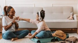 Suasana kehangatan sebuah keluarga yang sedang berdiskusi santai merencanakan peta perjalanan liburan bersama di ruang tamu rumah mereka.