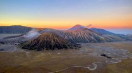 Pemandangan jalur pesisir selatan Jawa Timur yang membelah perbukitan hijau dengan latar belakang tebing terjal dan samudera biru nan membentang luas.