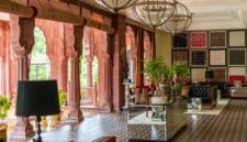 Interior lobi hotel bersejarah dengan sentuhan arsitektur klasik dan pencahayaan hangat yang menghadirkan suasana keanggunan masa lalu.