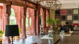 Interior lobi hotel bersejarah dengan sentuhan arsitektur klasik dan pencahayaan hangat yang menghadirkan suasana keanggunan masa lalu.
