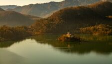 Pemandangan ikonik Danau Bled di Slovenia dengan gereja bersejarah di tengah pulau kecil yang dikelilingi perairan jernih dan perbukitan hijau Alpen.