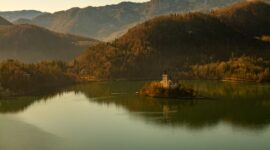 Pemandangan ikonik Danau Bled di Slovenia dengan gereja bersejarah di tengah pulau kecil yang dikelilingi perairan jernih dan perbukitan hijau Alpen.