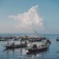 Sebuah perahu kayu tradisional melintas santai di antara tebing-tebing karang gugusan pulau Raja Ampat saat matahari mulai terbenam di ufuk barat. Lanskap bahari ini menjadi salah satu daya tarik utama pelancongan alam di Indonesia bagian timur.
