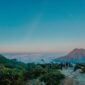 Sebuah kendaraan melintasi jalur darat dengan latar pemandangan alam pegunungan Indonesia yang asri. Kemudahan jalan menuju lokasi wisata kini memberikan kenyamanan lebih bagi para wisatawan domestik.