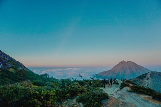 Sebuah kendaraan melintasi jalur darat dengan latar pemandangan alam pegunungan Indonesia yang asri. Kemudahan jalan menuju lokasi wisata kini memberikan kenyamanan lebih bagi para wisatawan domestik.