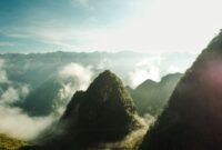 Penumpang menikmati pemandangan alam memukau dari balik jendela kereta api panorama yang melintasi kawasan pegunungan hijau saat fajar tiba.