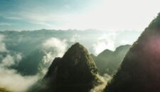 Penumpang menikmati pemandangan alam memukau dari balik jendela kereta api panorama yang melintasi kawasan pegunungan hijau saat fajar tiba.