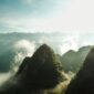 Penumpang menikmati pemandangan alam memukau dari balik jendela kereta api panorama yang melintasi kawasan pegunungan hijau saat fajar tiba.