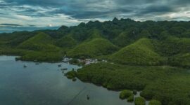 Pemandangan lanskap perbukitan hijau dan perumahan adat khas Sumba di Nusa Tenggara Timur yang menyajikan ketenangan alam pedalaman bagi para penjelajah.