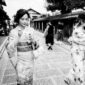 Suasana tenang di salah satu lorong bersejarah di kawasan Gion, Kyoto, di mana para pejalan kaki dapat merasakan kehangatan arsitektur kayu tradisional di tengah rinai hujan tipis.