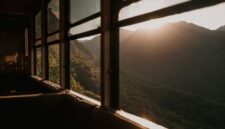 Wisatawan menikmati pemandangan perbukitan hijau dari dalam gerbong kereta wisata beratap kaca yang melintasi kawasan pedesaan di Jawa Barat.