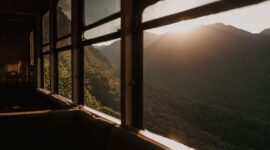 Wisatawan menikmati pemandangan perbukitan hijau dari dalam gerbong kereta wisata beratap kaca yang melintasi kawasan pedesaan di Jawa Barat.