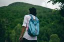 Seorang pelancong sedang menata barang bawaan dengan rapi sebelum memulai perjalanan. Pengemasan barang yang efisien menjadi salah satu kunci utama pengalaman liburan yang tenang dan menyenangkan.
