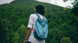 Seorang pelancong sedang menata barang bawaan dengan rapi sebelum memulai perjalanan. Pengemasan barang yang efisien menjadi salah satu kunci utama pengalaman liburan yang tenang dan menyenangkan.