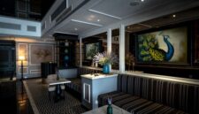 Keanggunan interior lobi hotel bersejarah yang memadukan detail arsitektur klasik zaman dulu dengan pencahayaan hangat, menciptakan atmosfer nostalgia yang mewah bagi para tamu.