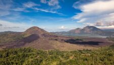 Pemandangan perairan jernih Kepulauan Banda Neira dengan latar belakang Gunung Api Banda yang megah saat matahari terbit.