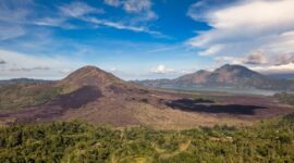 Pemandangan perairan jernih Kepulauan Banda Neira dengan latar belakang Gunung Api Banda yang megah saat matahari terbit.