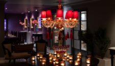 Interior lobi hotel berarsitektur klasik dengan lampu kristal gantung yang mencerminkan kemewahan era awal perkembangan perhotelan modern di Eropa.