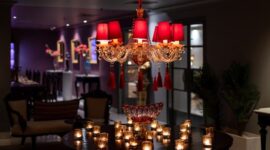 Interior lobi hotel berarsitektur klasik dengan lampu kristal gantung yang mencerminkan kemewahan era awal perkembangan perhotelan modern di Eropa.