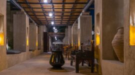 Interior megah sebuah hotel berarsitektur kolonial yang memadukan keanggunan lampu gantung klasik dengan ornamen kayu jati bernilai sejarah tinggi. Foto ini merekam kehangatan atmosfer masa lalu yang tetap terawat di tengah modernisasi kota.