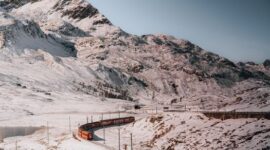 Penumpang menikmati pemandangan alam perbukitan hijau dari dalam kereta api berpanorama indah yang menjadi tren perjalanan lambat favorit para pelancong modern.
