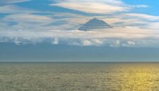 Pemandangan anggun Gunung Api Banda yang berdiri megah di seberang perairan tenang Banda Neira, Maluku, menjadikannya salah satu ikon wisata bahari dan sejarah paling memikat di Indonesia Timur.