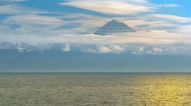 Pemandangan anggun Gunung Api Banda yang berdiri megah di seberang perairan tenang Banda Neira, Maluku, menjadikannya salah satu ikon wisata bahari dan sejarah paling memikat di Indonesia Timur.