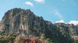 Tebing granit megah menjulang tinggi mengapit hamparan sawah hijau di kawasan ekowisata Lembah Harau, Kabupaten Lima Puluh Kota, Sumatra Barat.