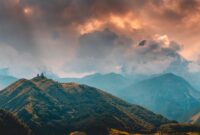 Pemandangan Gereja Gergeti Trinity yang berdiri megah di latar Pegunungan Kaukasus, Georgia, menjadi salah satu destinasi impian bagi pencinta *slow travel*.