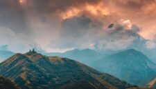 Pemandangan Gereja Gergeti Trinity yang berdiri megah di latar Pegunungan Kaukasus, Georgia, menjadi salah satu destinasi impian bagi pencinta *slow travel*.