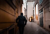 Seorang pengelana menikmati suasana pagi yang tenang di lorong bersejarah kota kuno sambil meresapi kehangatan budaya setempat.