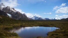 Seorang pendaki berjalan menyusuri jalur terjal dengan latar belakang puncak es dan danau alpine di kawasan Patagonia. Pemandangan lanskap murni ini menjadi salah satu daya tarik utama petualangan alam terbuka kelas dunia.