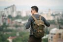 Seorang pelancong sedang mengemas barang bawaan dengan cermat ke dalam tas ransel sebelum memulai perjalanan akhir pekan yang santai.