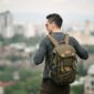Seorang pelancong sedang mengemas barang bawaan dengan cermat ke dalam tas ransel sebelum memulai perjalanan akhir pekan yang santai.