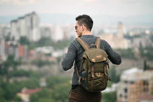 Seorang pelancong sedang mengemas barang bawaan dengan cermat ke dalam tas ransel sebelum memulai perjalanan akhir pekan yang santai.
