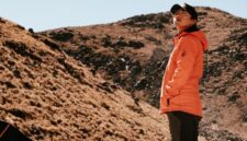 Seorang pendaki berdiri menatap megahnya gugusan puncak granit Torres del Paine di Chile yang dikelilingi lanskap subpolar liar dan danau glasial.