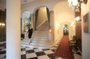 Suasana interior penginapan klasik yang mempertahankan kemegahan arsitektur era tempo dulu serta memberikan sentuhan nostalgia hangat bagi para tamu.