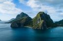 Pemandangan udara gugusan pulau karang menakjubkan yang dikelilingi perairan jernih bergradasi biru di kawasan wisata bahari unggulan Indonesia.