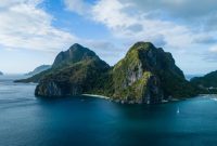 Pemandangan udara gugusan pulau karang menakjubkan yang dikelilingi perairan jernih bergradasi biru di kawasan wisata bahari unggulan Indonesia.