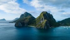 Pemandangan udara gugusan pulau karang menakjubkan yang dikelilingi perairan jernih bergradasi biru di kawasan wisata bahari unggulan Indonesia.