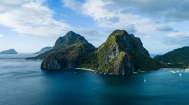 Pemandangan udara gugusan pulau karang menakjubkan yang dikelilingi perairan jernih bergradasi biru di kawasan wisata bahari unggulan Indonesia.